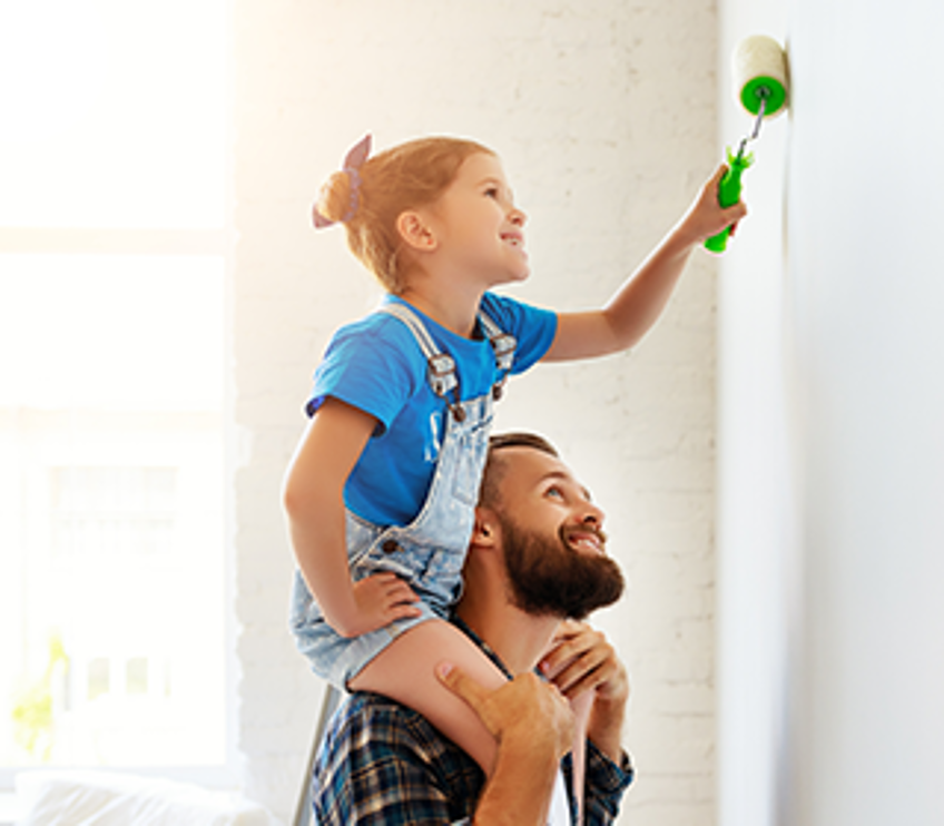 DEVK Assurance-vie : Père et fille peignent un mur dans la chambre 